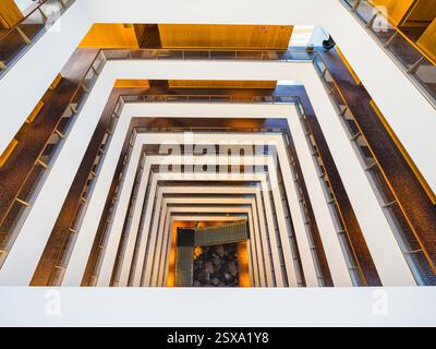 L'hôtel présente un design géométrique saisissant avec plusieurs étages et des lignes épurées. La lumière naturelle illumine l'intérieur, améliorant l'ambi moderne Banque D'Images