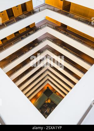 L'hôtel présente un design géométrique saisissant avec plusieurs étages et des lignes épurées. La lumière naturelle illumine l'intérieur, améliorant l'ambi moderne Banque D'Images