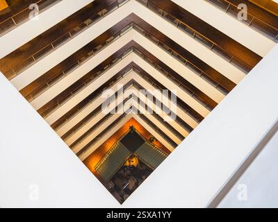 L'hôtel présente un design géométrique saisissant avec plusieurs étages et des lignes épurées. La lumière naturelle illumine l'intérieur, améliorant l'ambi moderne Banque D'Images