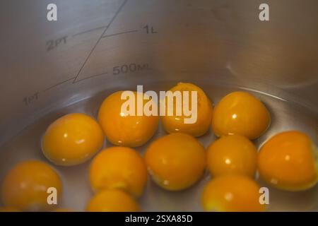 Confection maison avec des fruits frais - gros plan de groseilles à maquereau du Cap / physalis bouillant dans une casserole. . Banque D'Images