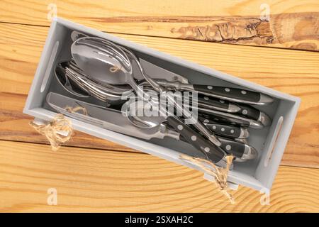 Couverts dans une boîte en bois sur une table en bois, gros plan, vue de dessus. Banque D'Images