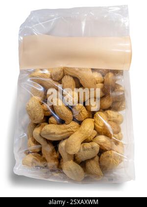 Cacahuètes dans un sac en cellophane transparent avec étiquette vide avec espace de copie, isolé sur blanc avec chemin de découpage inclus Banque D'Images