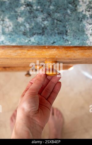 La main de la femme ouvre l'ancien tiroir de cuisine dans la cuisine à la maison vue de dessus en bas, meubles de cuisine Banque D'Images