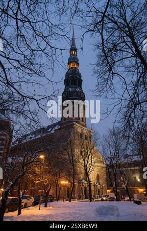 – Peter Church à Riga, Lettonie, par une soirée hivernale enneigée. L'église gothique historique, construite à l'origine au XIIIe siècle, dispose d'un illuminé Banque D'Images