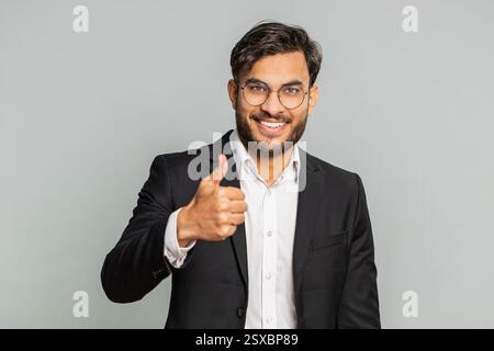 J'aime. L'homme d'affaires indien soulève les pouces vers le haut est d'accord avec quelque chose ou donne une réponse positive recommande la publicité aime la rétroaction de bonne idée, célébrant la victoire de succès. Homme isolé sur fond gris Banque D'Images