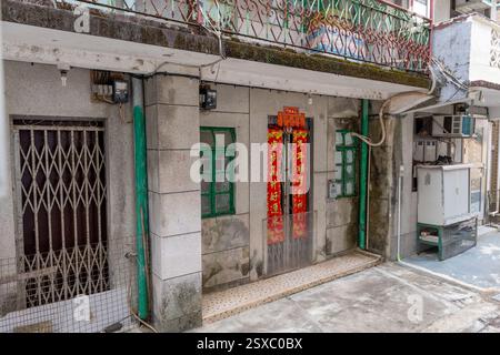 Hong Kong. Chine- 02.13.2025. Des couplets de printemps chinois accrochés à la porte d'une maison de village de style ancien. Banque D'Images