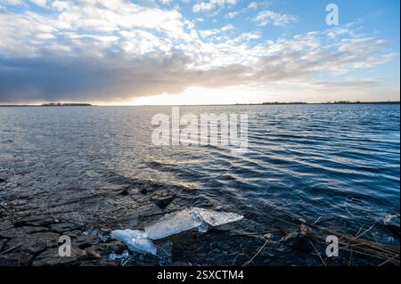 Impression d'un coucher de soleil sur une soirée d'hiver glaciale relativement froide dans la province néerlandaise de Frise. L'image est près de la ville de lemmer et la pompe à eau classique à vapeur woudagemaal. Banque D'Images