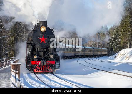 Ruskeala, RUSSIE - 20 FÉVRIER 2025 : le train rétro 'Ruskealski express' arrive à la gare. Carélie, Russie Banque D'Images