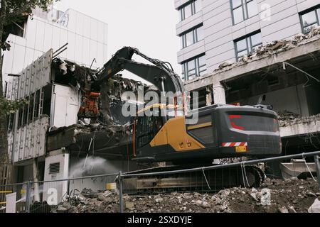 Une excavatrice démolit un bâtiment dans le centre-ville Banque D'Images