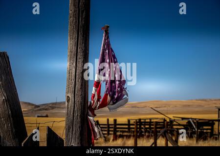 Drapeau américain en lambeaux sur rural Fence Post Banque D'Images
