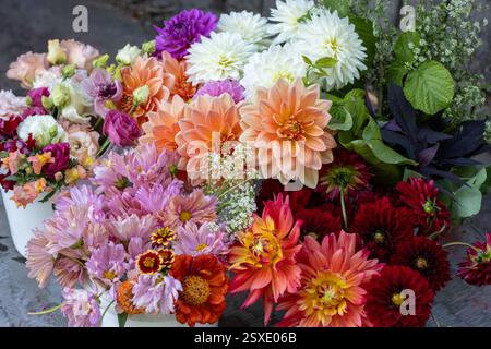 Seaux de fleurs colorées et de verdure sur une table en métal Banque D'Images