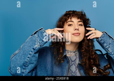 Une jeune femme élégante exprime ses émotions à travers sa pose audacieuse et sa tenue à la mode. Banque D'Images
