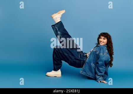 Une jeune femme belle et à la mode prend une pose ludique, mettant en valeur son expression émotionnelle. Banque D'Images
