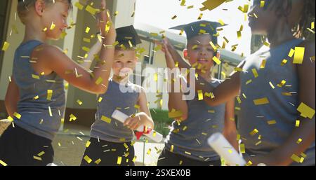 Image de confettis dorés sur des écoliers heureux divers avec des diplômes jetant des mortarboards Banque D'Images
