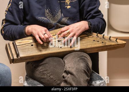 Doigts d'une fille jouant des kankles, instrument à cordes plumé lituanien appartenant à la famille de la cithère Baltique connue sous le nom de psaltère Baltique Banque D'Images