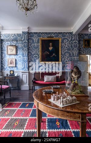 Échiquier sur la table avec papier peint bleu 'Pomegranate Grand' dans Bayfield Hall, une maison de campagne historique du 18ème siècle à Norfolk, Royaume-Uni. Banque D'Images