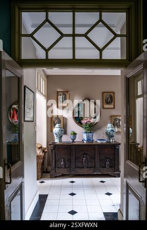 Fenêtre géométrique au-dessus de la porte avec vue sur les gravures françaises au-dessus du coffre élisabéthain sculpté à Bayfield Hall, une maison de campagne du XVIIIe siècle dans le Norfolk Banque D'Images