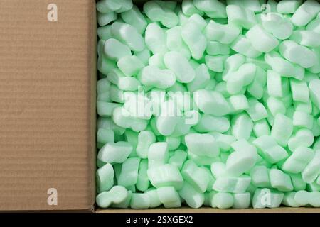 Copeaux d'emballage en vrac verts dans une boîte : expédier en toute sécurité des articles et des produits fragiles Banque D'Images
