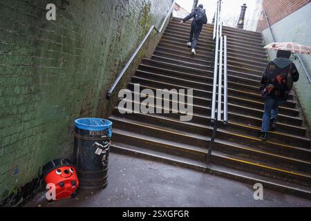Un aspirateur rouge « Henry Home » se trouve à côté d'une poubelle dans le passage inférieur sous la gare de Forest Hill dans le sud de Londres, le 20 février 2025, à Londres, en Angleterre. Banque D'Images