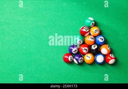 Boules de billard en triangle sur table verte, vue de dessus. Espace pour le texte Banque D'Images