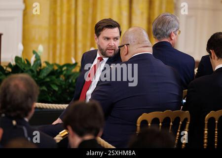 Washington, États-Unis. 24 février 2025. Le vice-président JD Vance discute avec le directeur de la communication de la Maison Blanche Steven Cheung lors d’une conférence de presse conjointe avec le président américain Donald Trump et le président français Emmanuel Macron (non représenté sur la photo) dans la salle est de la Maison Blanche à Washington DC le lundi 24 février 2025. Emmanuel Macron et d’autres dirigeants européens rencontrent le président Trump alors que l’administration Trump menace de couper l’aide étrangère et le soutien à l’Ukraine. (Photo de Aaron Schwartz/Sipa USA) crédit : Sipa USA/Alamy Live News Banque D'Images