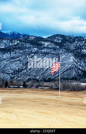 Le drapeau américain souffle dans le vent froid de l'hiver devant les montagnes San Juan dans le sud du Colorado. Banque D'Images