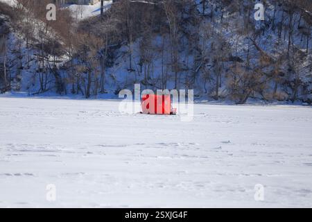 Tentes de pêche sur glace installées sur une baie gelée au cœur de l'hiver Banque D'Images