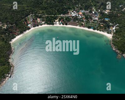 Plage tropicale immaculée aux eaux vert émeraude, bordée de verdure luxuriante et de stations balnéaires colorées. Ko Pha Ngan, Thaïlande. Banque D'Images