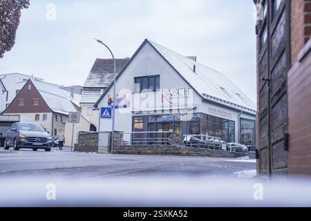 Bâtiment commercial dans une rue enneigée avec voitures garées et panneaux de signalisation, Aidlingen, quartier de Boeblingen, Allemagne, Europe Banque D'Images