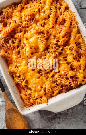 Délicieuse casserole Sloppy joe avec viande, pâtes, légumes et sauce et beaucoup de gros plan de fromage dans un plat de cuisson sur la table. Vue de dessus verticale de ci-dessus Banque D'Images