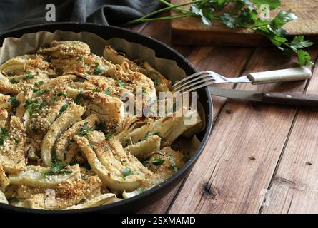 Gratin de fenouil au fromage maison avec parmesan et persil sur fond de bois. Nourriture saine et végétarienne. Directement au-dessus Banque D'Images