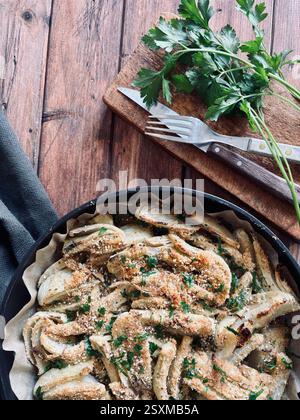 Gratin de fenouil au fromage maison avec parmesan et persil sur fond de bois. Nourriture saine et végétarienne. Directement au-dessus Banque D'Images