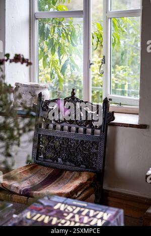 Chaise antique sculptée à fenêtre ouverte dans Chalford tisserands cottage dans les Cotswolds, Gloucestershire, Angleterre, Royaume-Uni. Banque D'Images