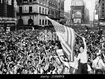 Des foules brandissant des drapeaux célèbrent la reddition du Japon dans un quartier bondé de Times Square, New York City, États-Unis d'Amérique, le 17 août 1945. Banque D'Images