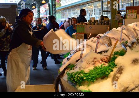 Un ouvrier garde le poisson congelé au marché aux poissons de Pike Street à Seattle Banque D'Images