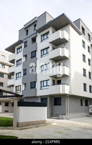 Bâtiment résidentiel moderne générique blanc et gris avec balcons et volets noirs Banque D'Images