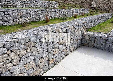 Murs de gabion modernes faits de pierres de granit et de treillis métallique, utilisés pour l'aménagement paysager sur un parc public Banque D'Images