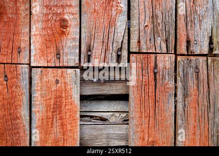 Vue rapprochée de planches de bois altérées affichant des textures et des couleurs riches, transmettant un charme rustique dans un endroit tranquille de campagne. Banque D'Images