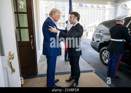 Le président Donald Trump salue le président français Emmanuel Macron, lundi 24 février 2025, dans le hall de l’aile ouest de la Maison Blanche. (Photo officielle de la Maison Blanche par Daniel Torok) Banque D'Images