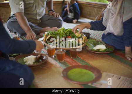 Les gens mangent de la nourriture sundanaise appelée lalapan nasi timbel Banque D'Images
