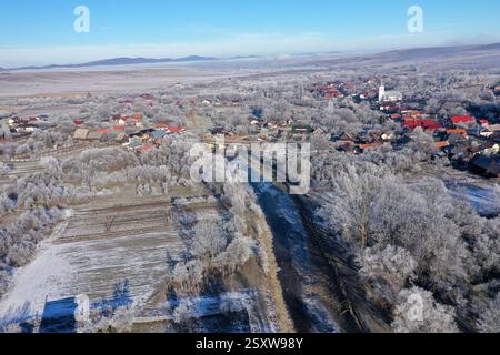 Vue aérienne d'un village de campagne brumeuse, dans les lumières tôt le matin par drone Banque D'Images