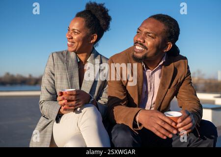 Un homme et une femme d'affaires joyeux habillé dans chic décontracté ayant une conversation sur le café en pause Banque D'Images