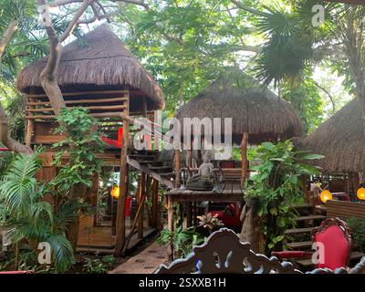 Restaurant tropical rustique de style cabane dans les arbres avec toits de chaume, structures en bois et verdure luxuriante dans un cadre de jungle, Mexique Banque D'Images