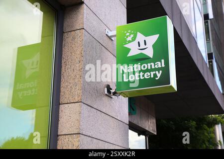 DUBLIN, IRLANDE - 6 JUILLET 2024 : bannière publicitaire de la loterie nationale devant une épicerie à Dublin, Irlande. Banque D'Images