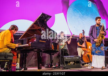 Séville, Espagne, 21 juin 2022, Ariel Bringuez joue énergiquement du saxophone tandis que son groupe l'accompagne sur scène lors d'un festival de musique dynamique. Banque D'Images
