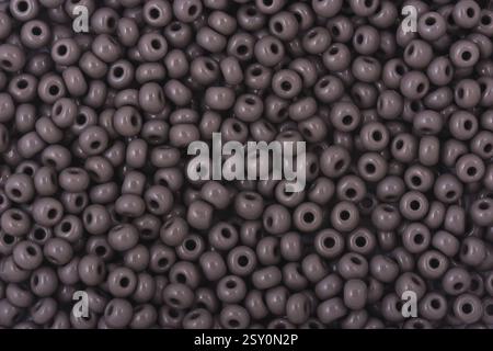 Perles grises sur le fond blanc. Fond ou texture de perles. Gros plan, macro, il est utilisé dans la finition des vêtements de mode. confectionnez un collier de perles ou st Banque D'Images