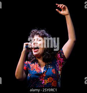 Un chanteur de jazz dynamique se produisant passionnément sur scène, exprimant des émotions à travers la musique. Banque D'Images