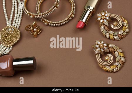 Bijoux de perles sur un fond marron, rouge à lèvres, bracelet de perles, vernis à ongles, collier de perles, boucles d'oreilles en perles, bague de doigt. Style, mode et design de j Banque D'Images
