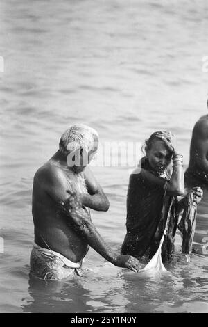 Couple baignant Makar Sankranti Hoogly rivière Kolkata West Bengale Inde Asie 1977 Banque D'Images