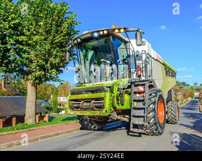 Moissonneuse-batteuse CLAAS Lexion 6700 conduite dans le village - Bossay-sur-Claise, Indre-et-Loire (37), France. Banque D'Images